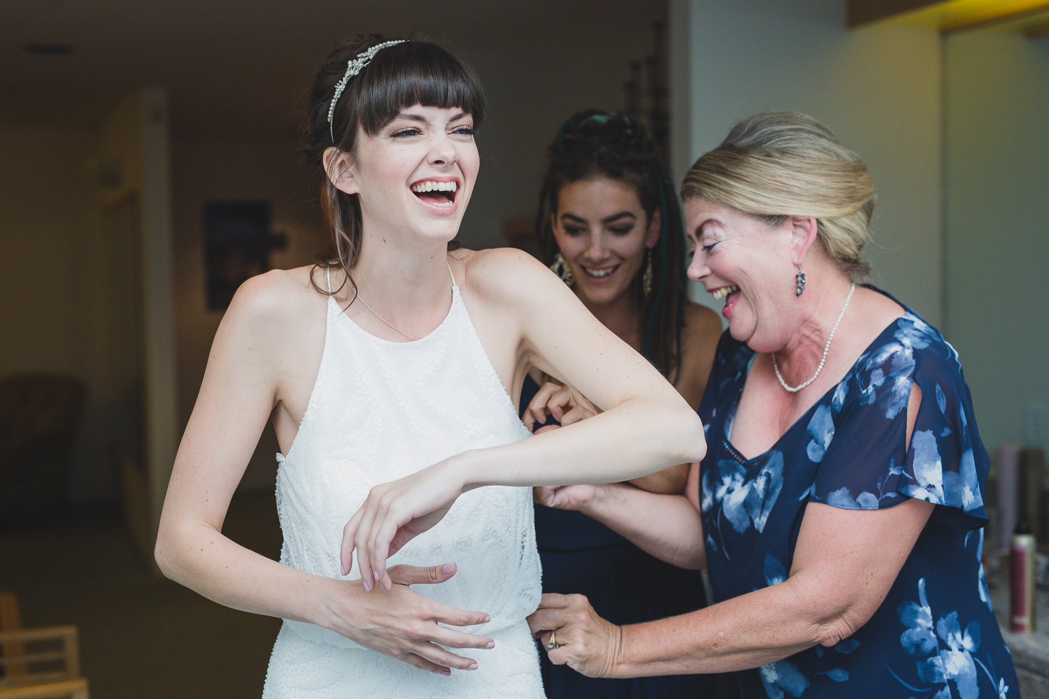 Bride and mom having fun putting on dress at Squamish wedding